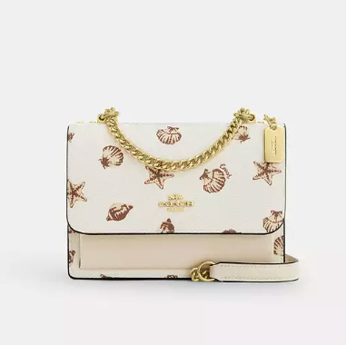 Cartera Coach beige con diseño de conchitas